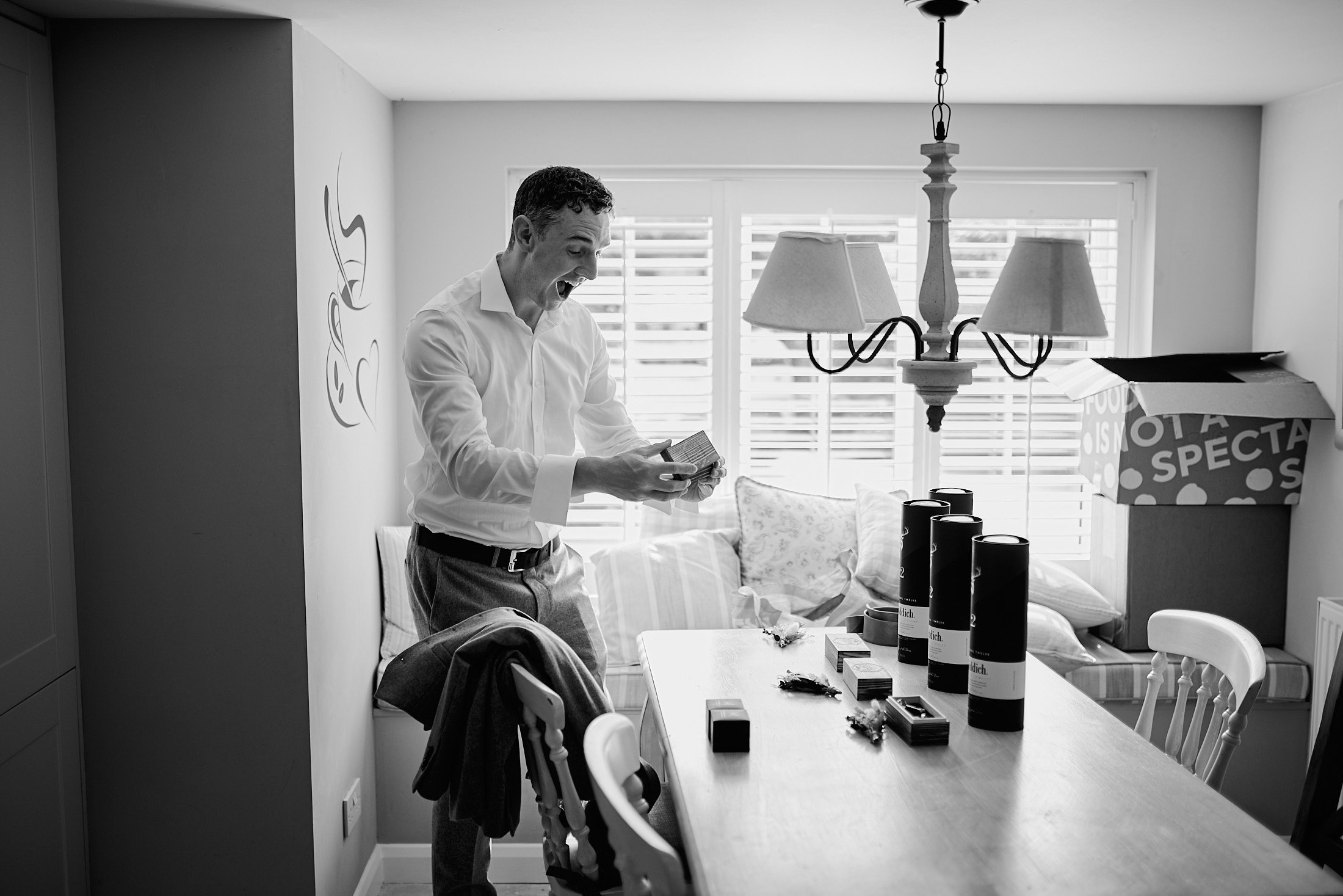 groomsman opening a personalised gift during groom prep