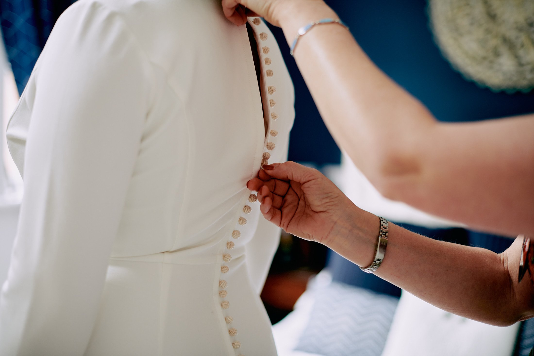 bridal dress being fastened 