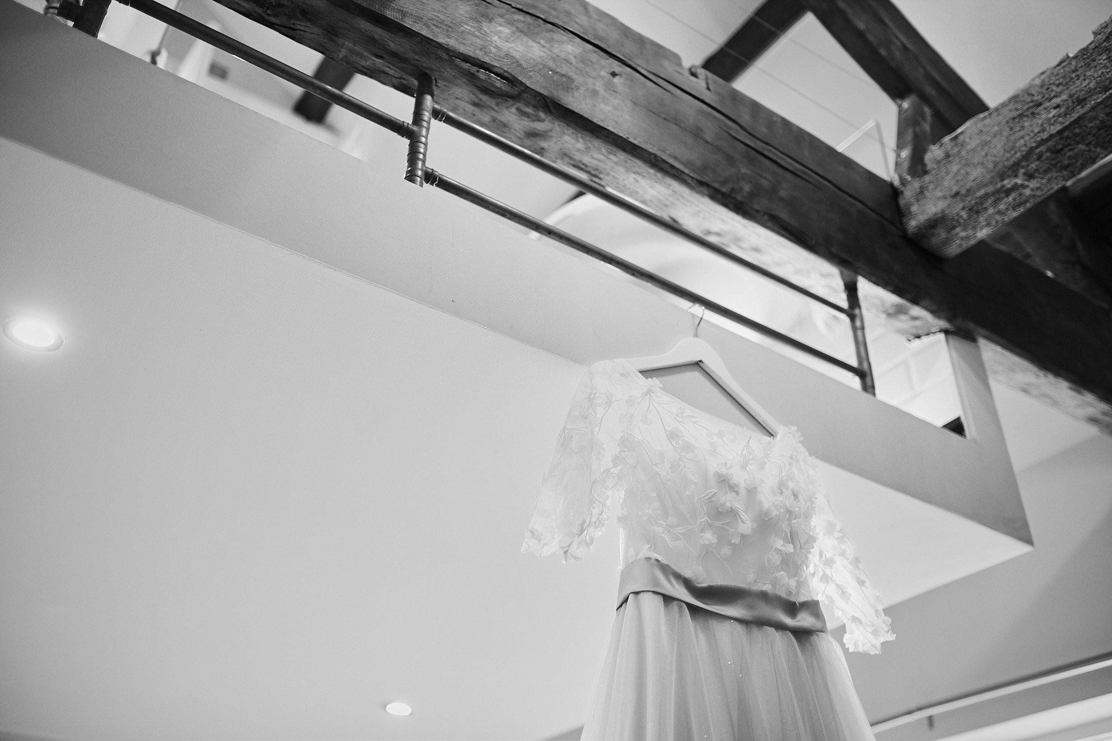 wedding dress hung up on wooden beams