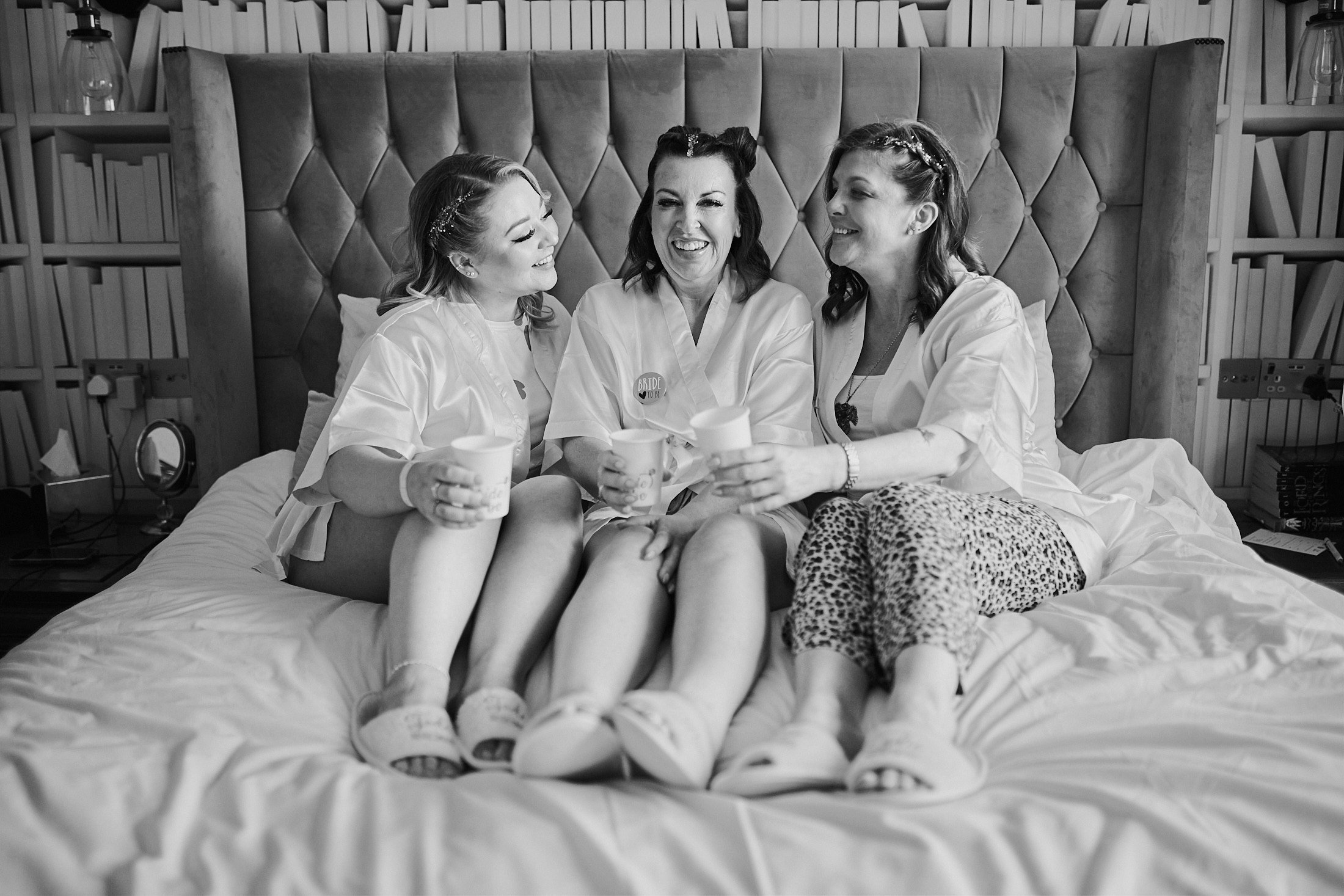 bride with bridesmaids sat on bed