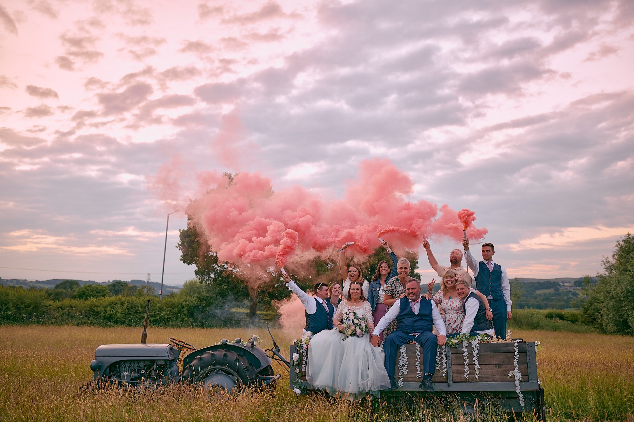 pink smoke bombs with bridal party at festival theme wedding