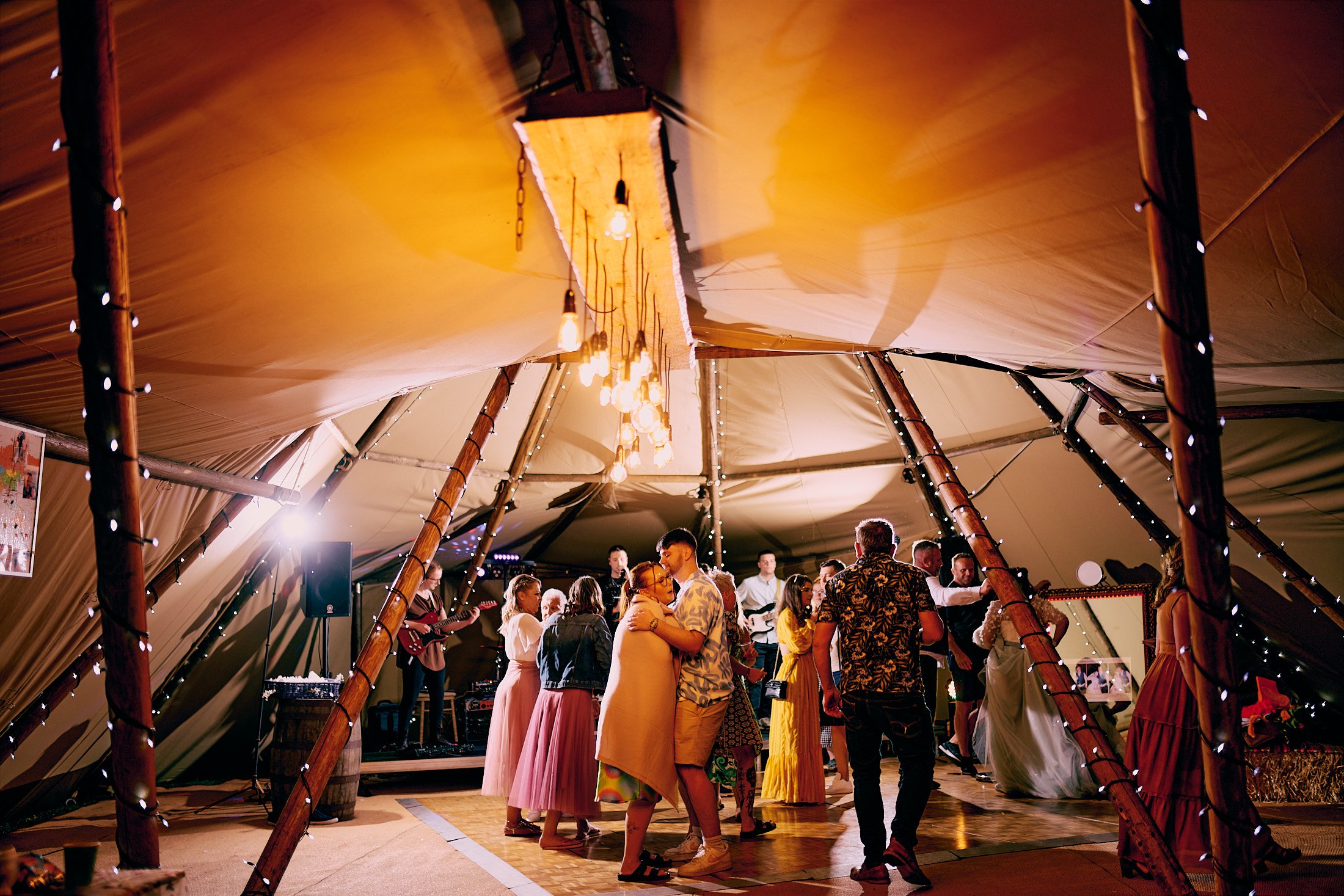 party in teepee tent at festival theme wedding