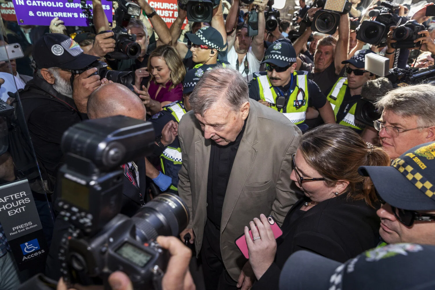 George Pell is surrounded by police and media as he enters Victoria’s County Court (Image: AAP)