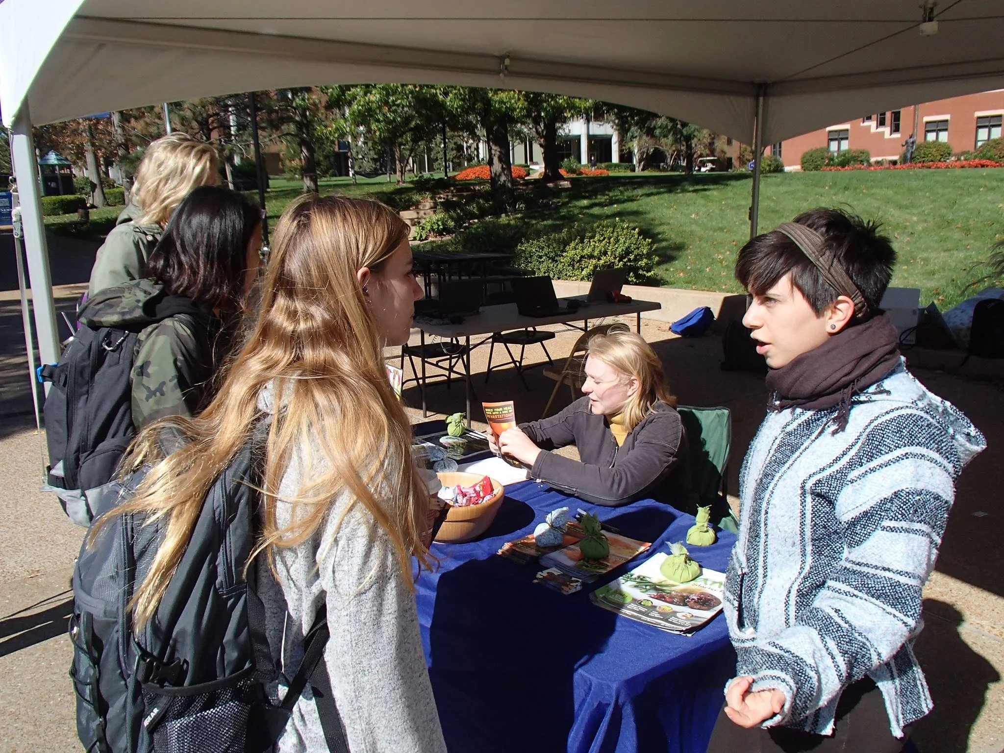 Students at St. Louis University discussing plant-based living with passersby