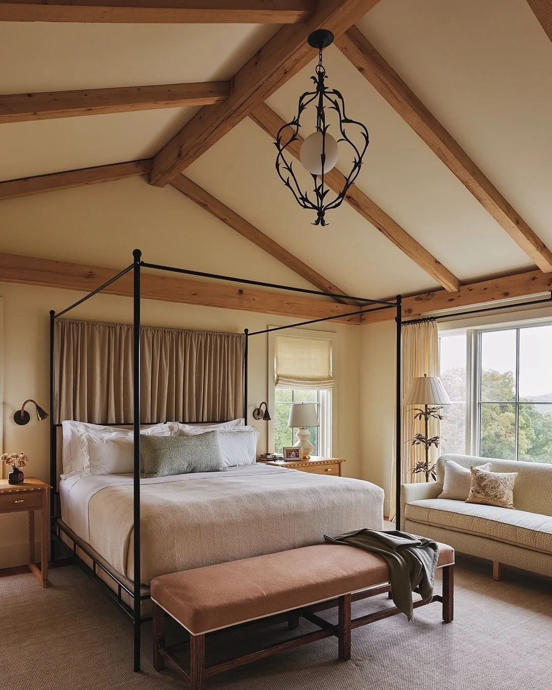 At our #LakeWaramaug project, wooden beams and layers of textures add depth to the main bedroom. The back of the four-posted is hung with &lsquo;Little Stripe&rsquo; by @nicholasherbertltd, which, together with a layering of brass wall lights, and a 