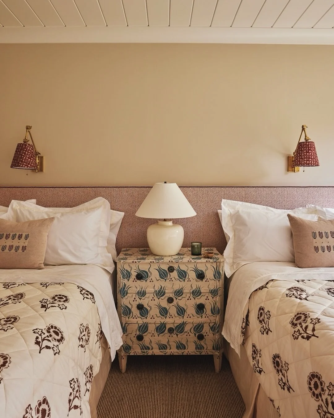 At our #LakeWaramaug project, in the guest wing, a double bedroom features curtains and bed quilts in &lsquo;Madame de Montreuil&rsquo; by @les_indiennes. On the walls, @visualcomfort &lsquo;Graves&rsquo; sconces with a custom lampshade by @robertkim