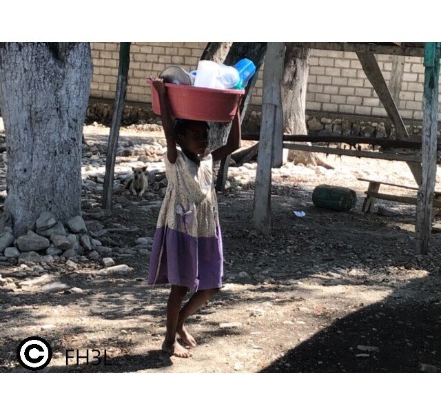 Un enfant transportant la vaisselle à laver.jpeg