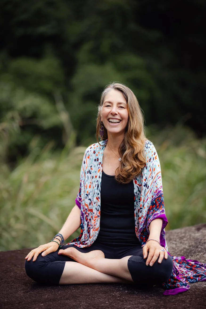 Julie Wood on a rock smiling