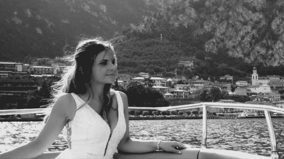 Woman on a boat in front of a mountainous landscape