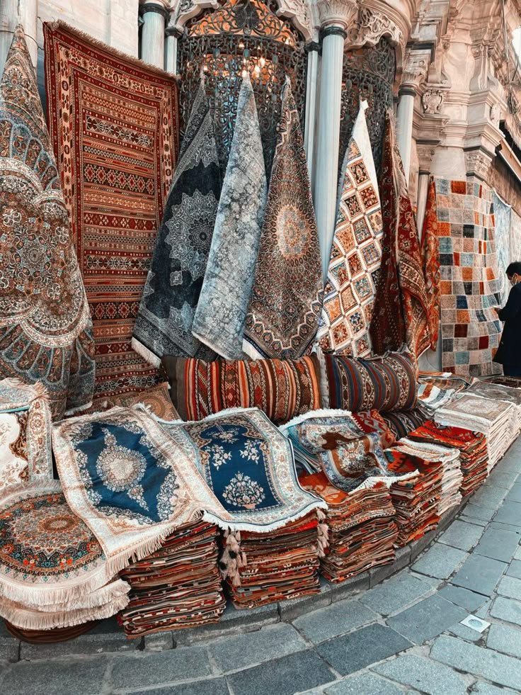 Mercado con alfombras y tapetes coloridos exhibidos en una tienda al aire libre.