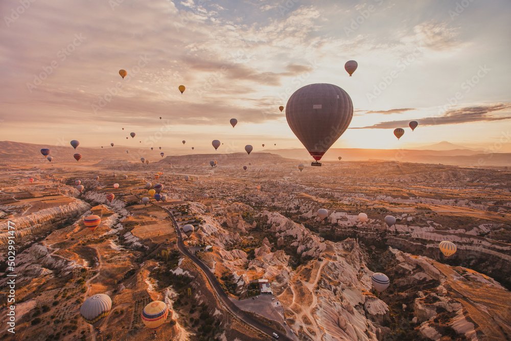 Globos aerostáticos sobre un paisaje de rocas al amanecer en Capadocia, Turquía.