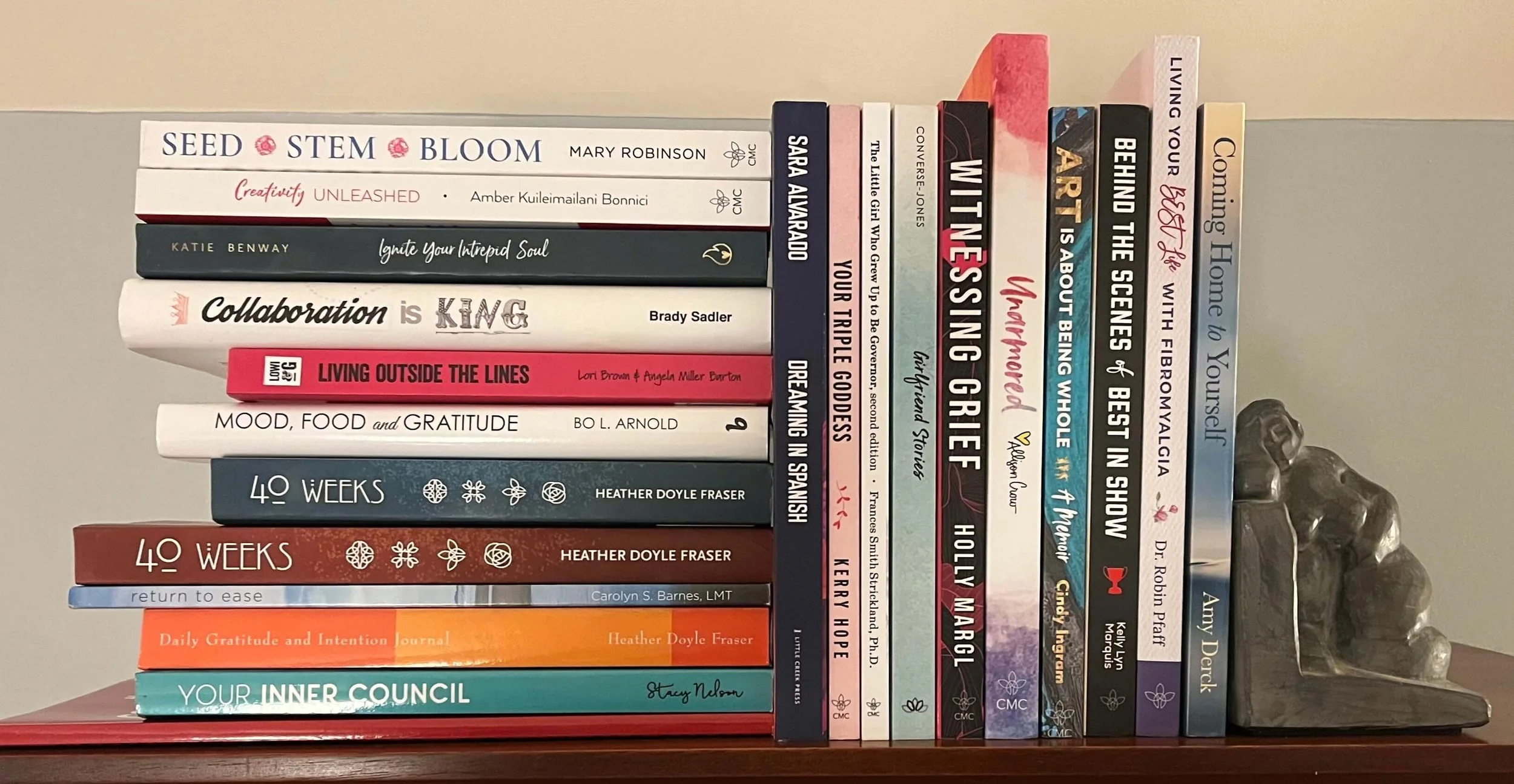 A stack and shelf of books that Heather has published