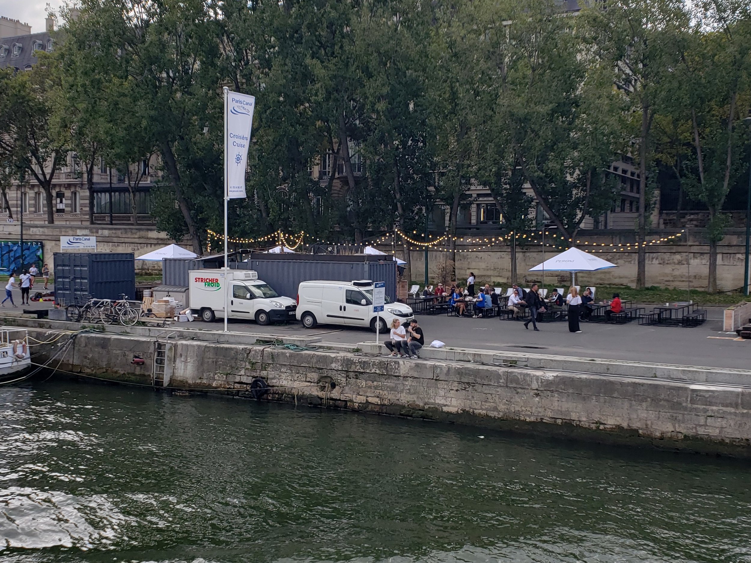 A cafe with outdoor seating along the Seine