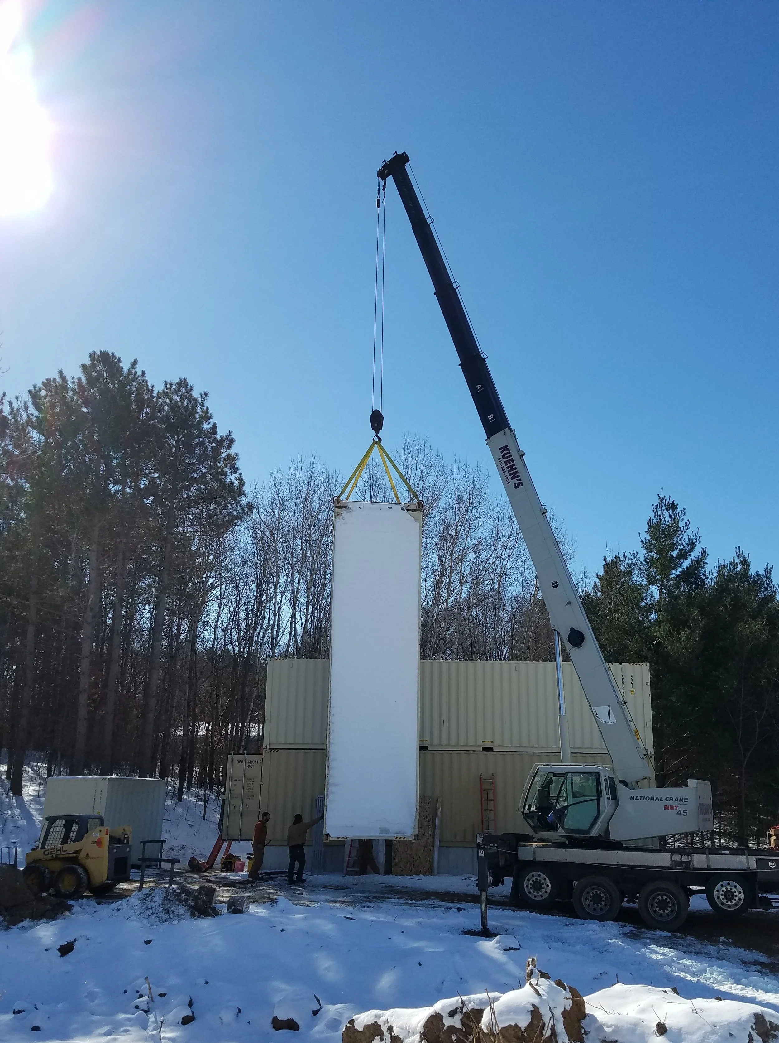 container moved by crane into project space