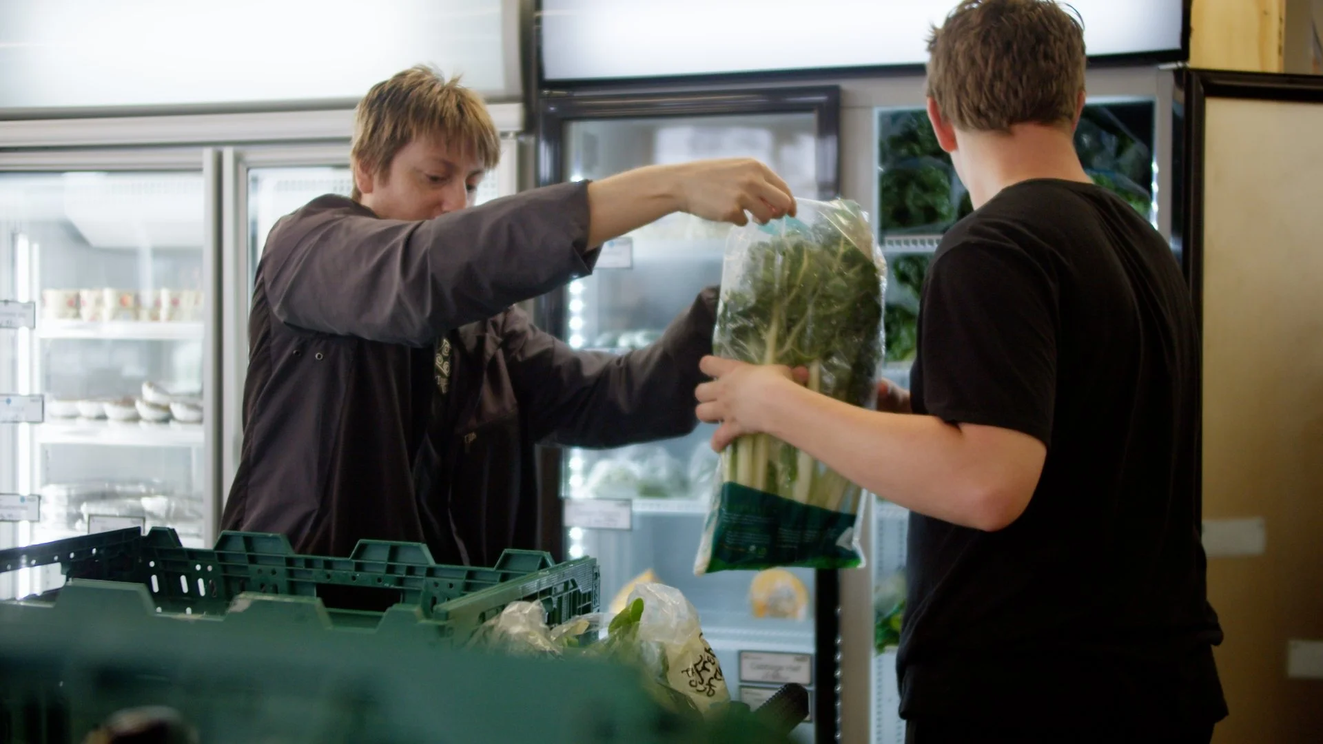 Taimahi trainee hands silverbeet to another trainee.