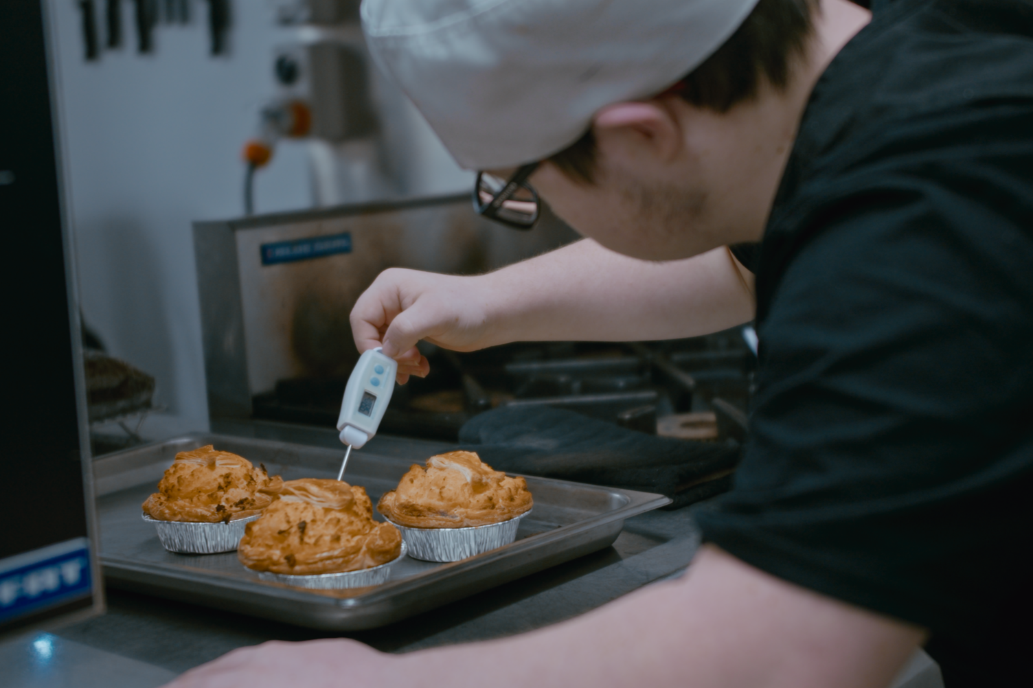 A Taimahi trainee is pictured checking the temperature of freshly baked pies