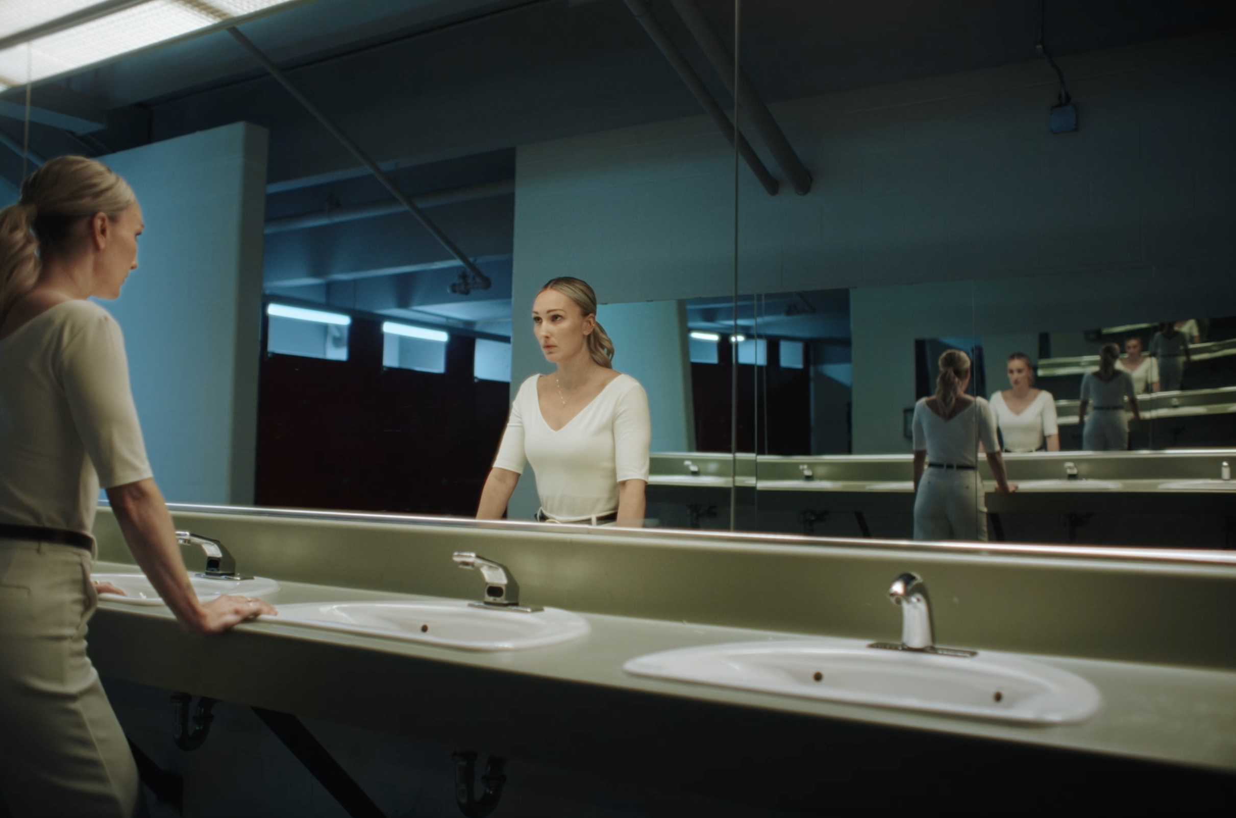 Jessica Campbell looking at her reflection in the mirror of the arena bathroom