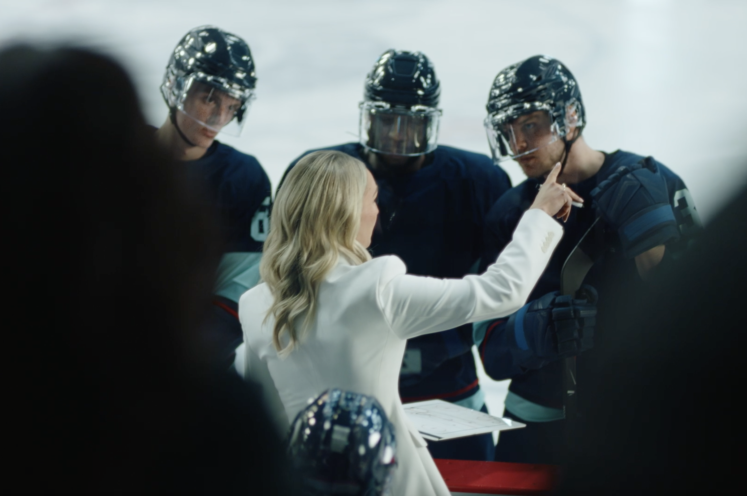 Jessica directing hockey players at the side of the rink