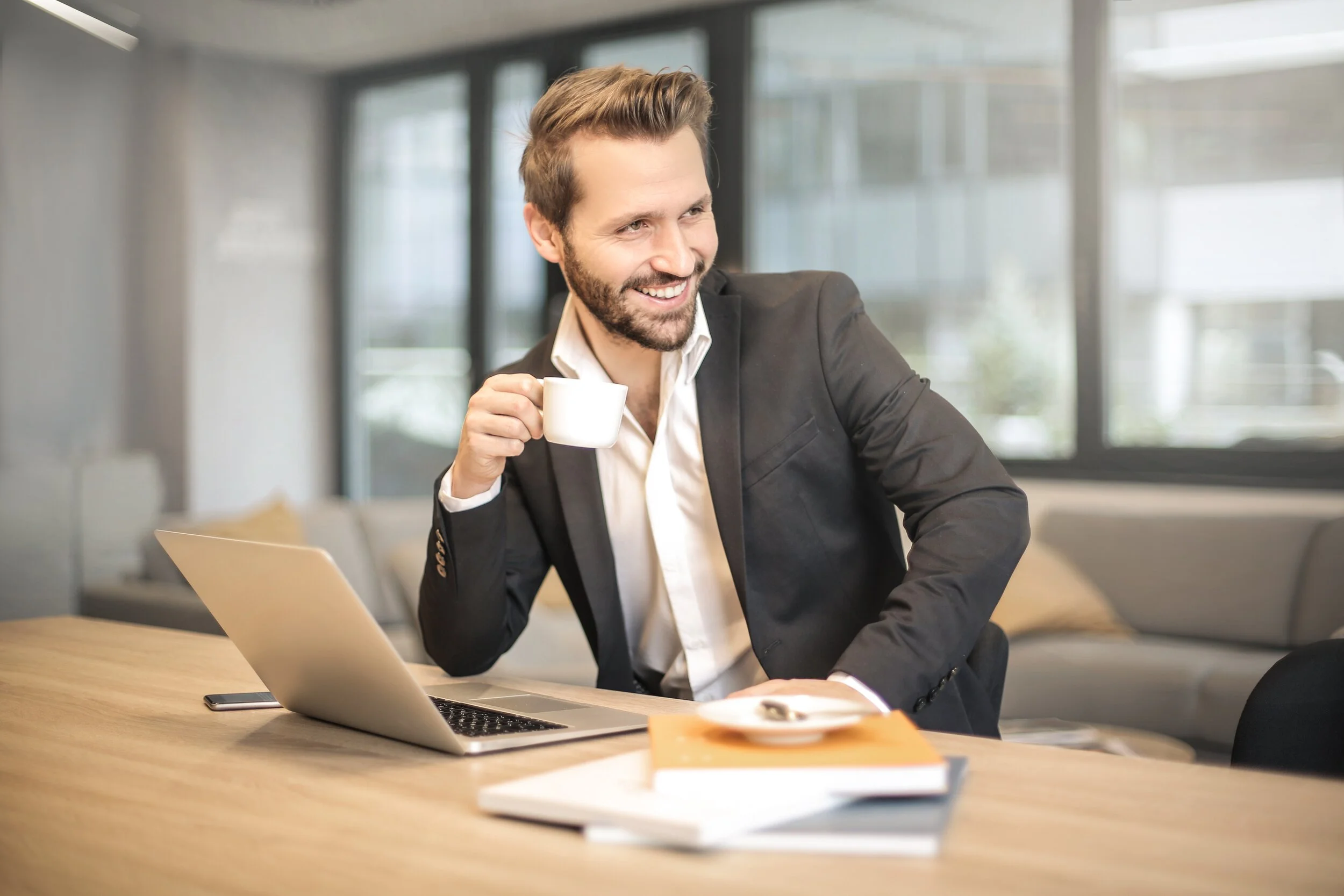 man-holding-white-teacup-in-front-of-gray-laptop-842567 (1).jpg