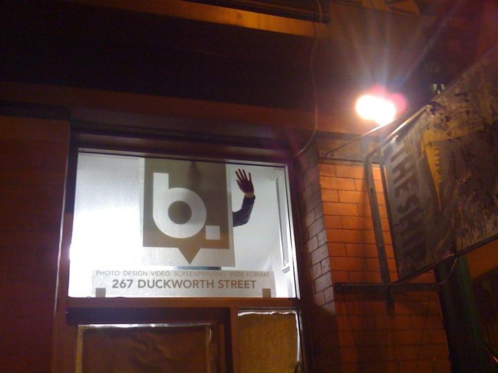  Applying vinyl signage to the window of the studio. 