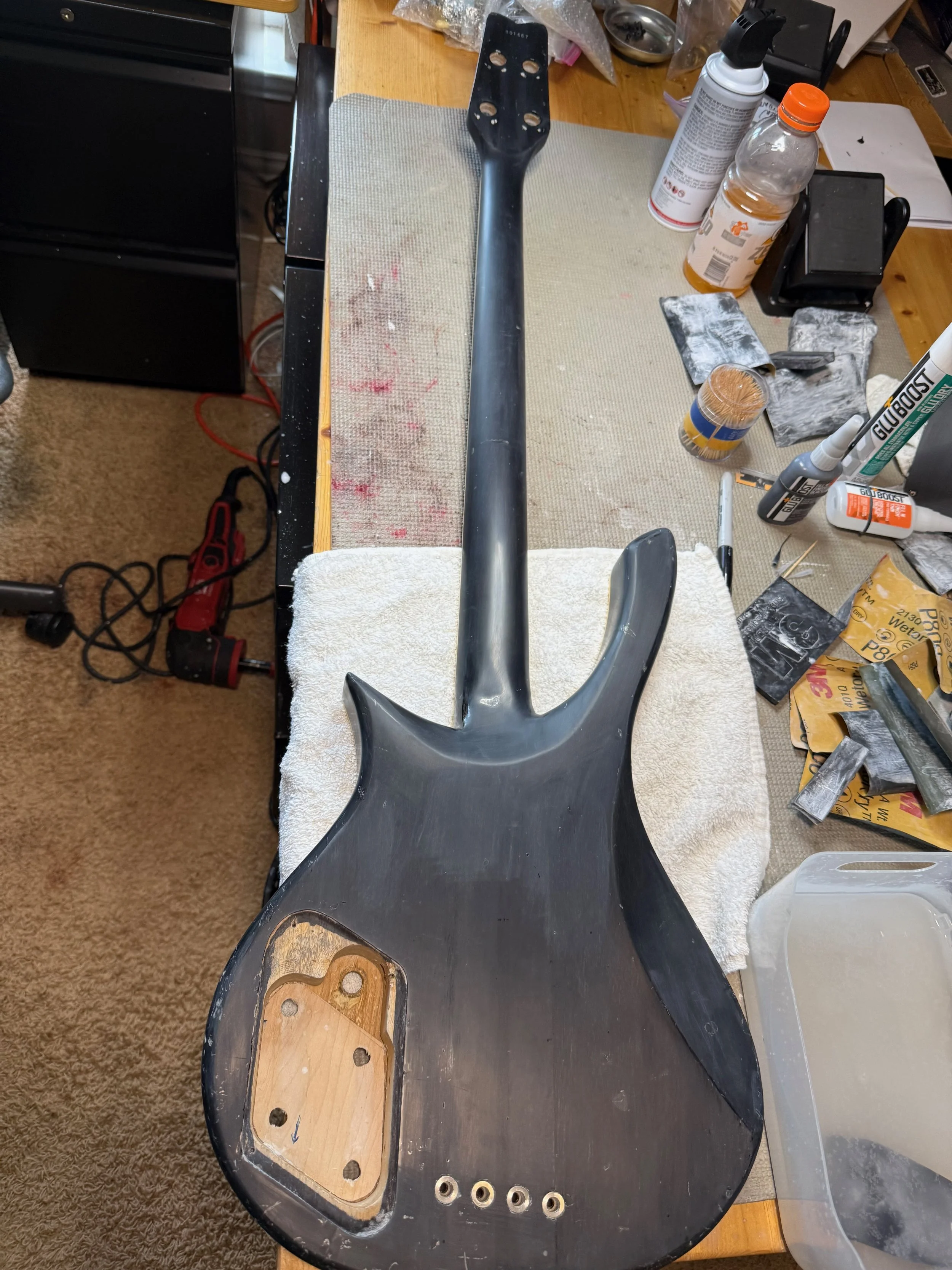 Wet sanding. You can see that holes have been drilled into the reinforcement plate in the control cavity
