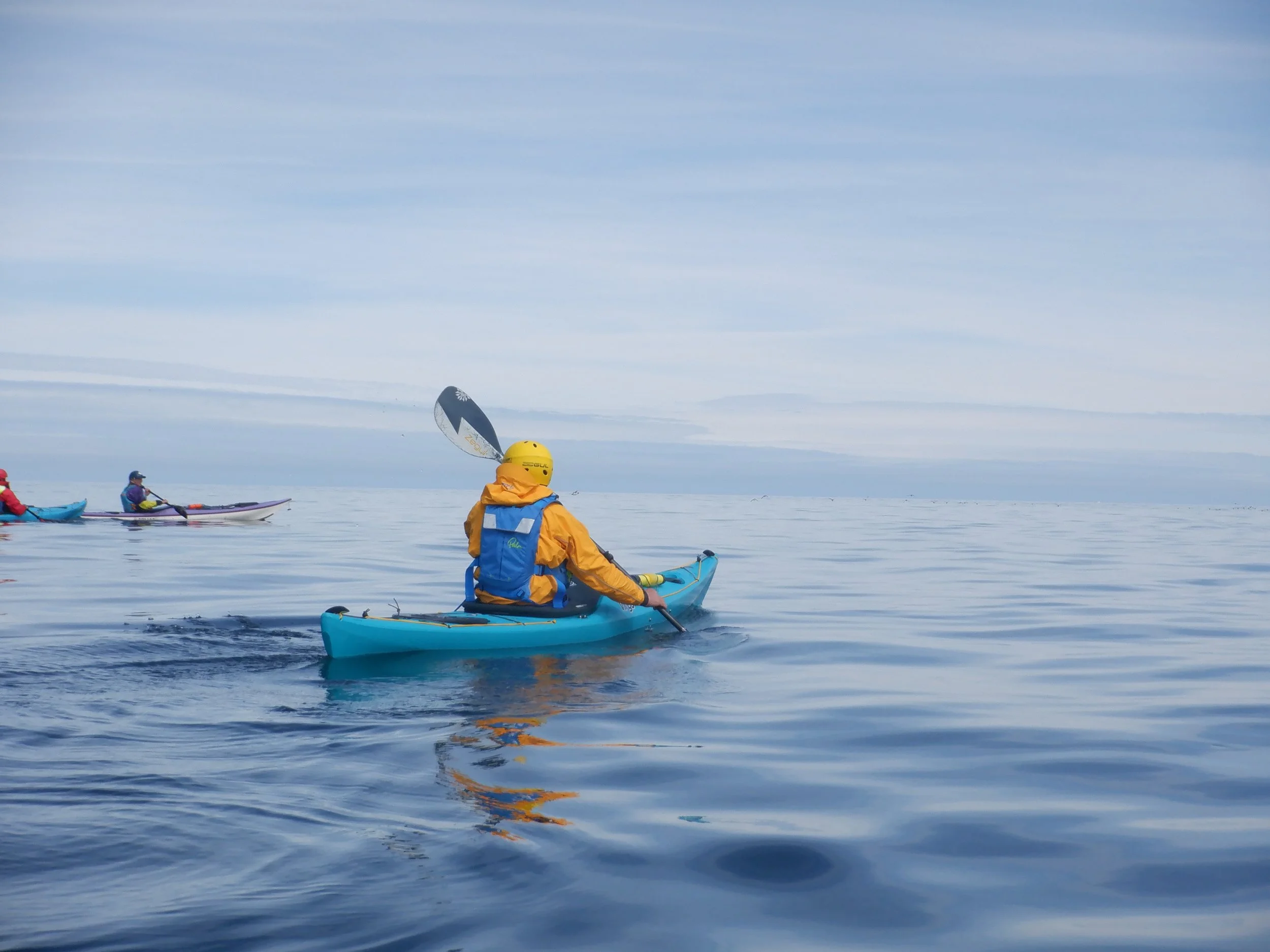 Kayaker in kayak on the sea off Anglesey on a Sea Kayaking Wales Course