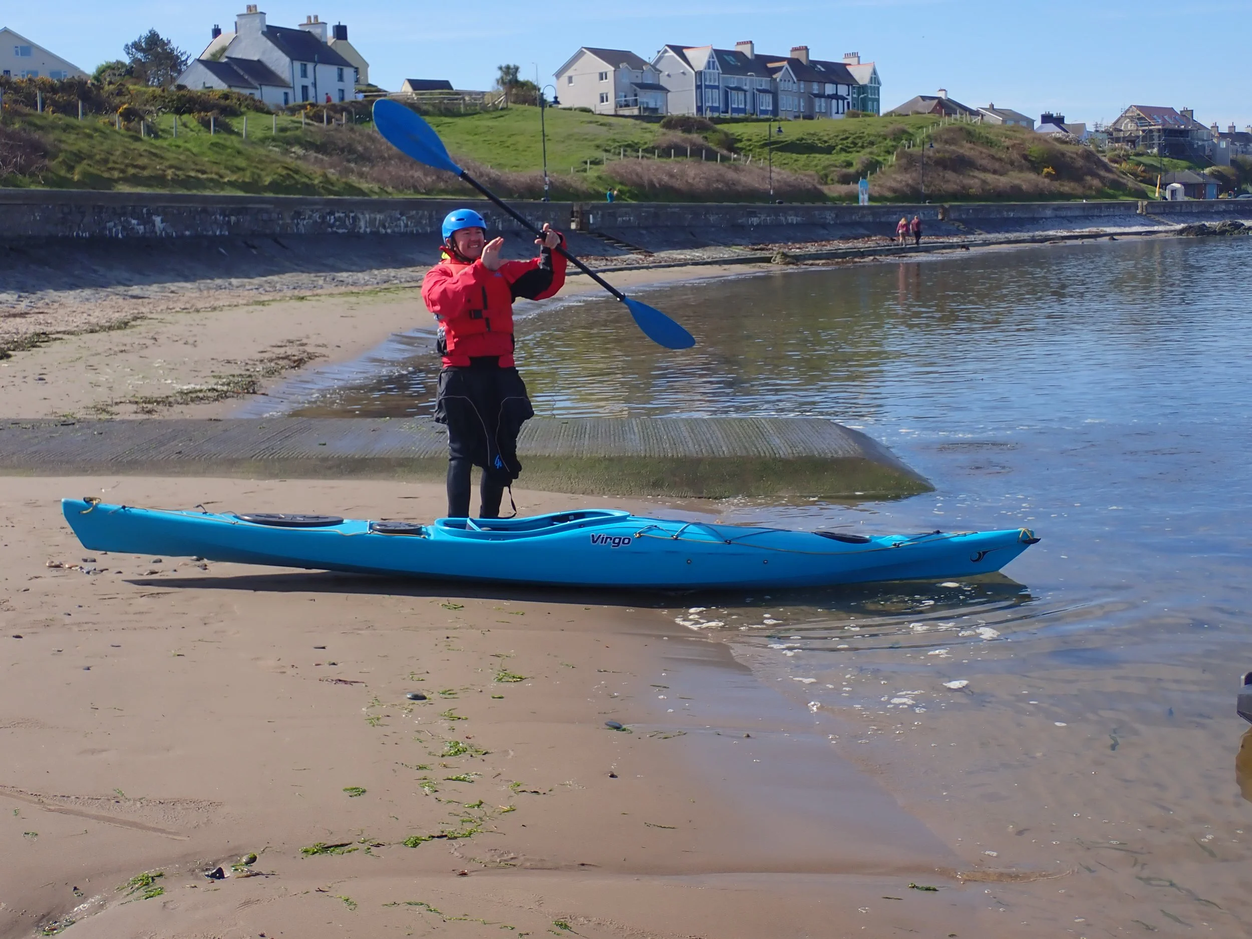 Beginner sea kayaking group launching on sheltered water in Anglesey, North Wales