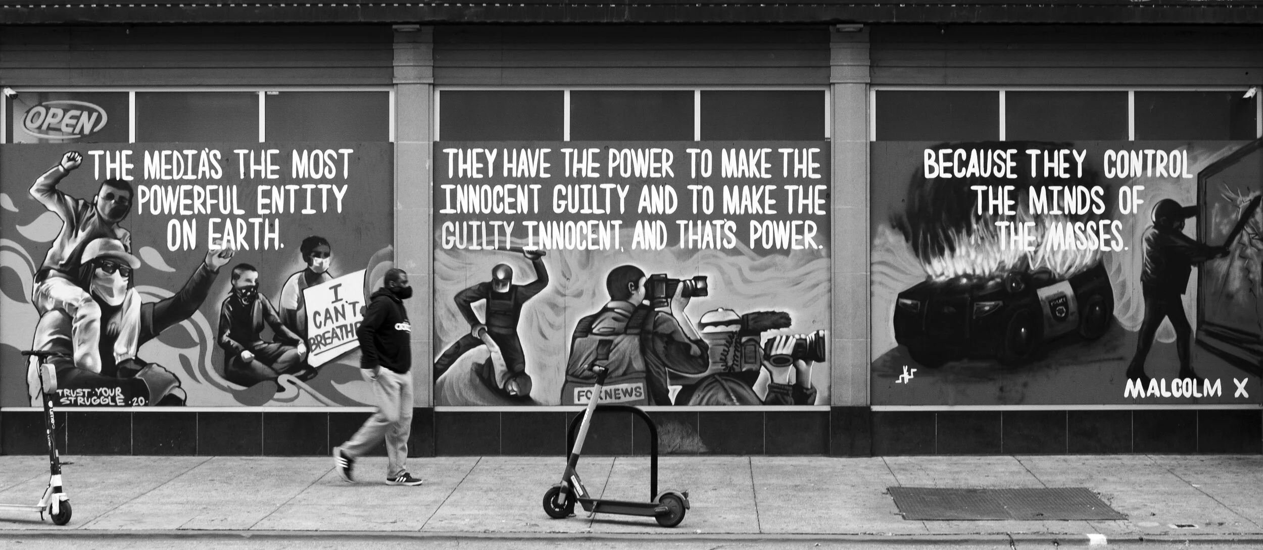 FeatureA pedestrian walks by a mural that is depicting the role of the media along with a Malcolm X quote in Downtown Sacramento, Ca. Photo taken by: Sarah Hussey