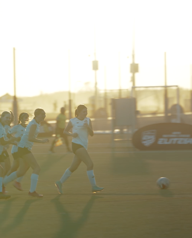 Youth soccer players training at sunset, vertical social video
