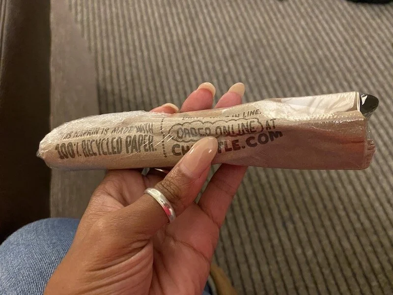 Picture of me holding the plastic-wrapped plasticware.
