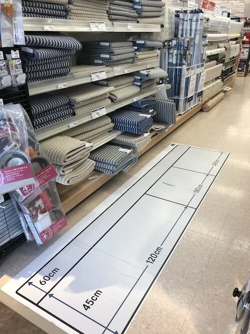 Image of measuring chart decal on the store floor in the rug aisle.