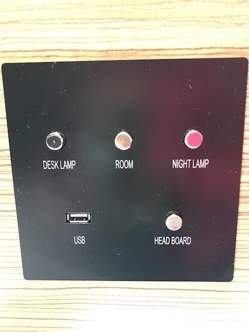 Image of lighting control panel from a hotel room located near the bed.