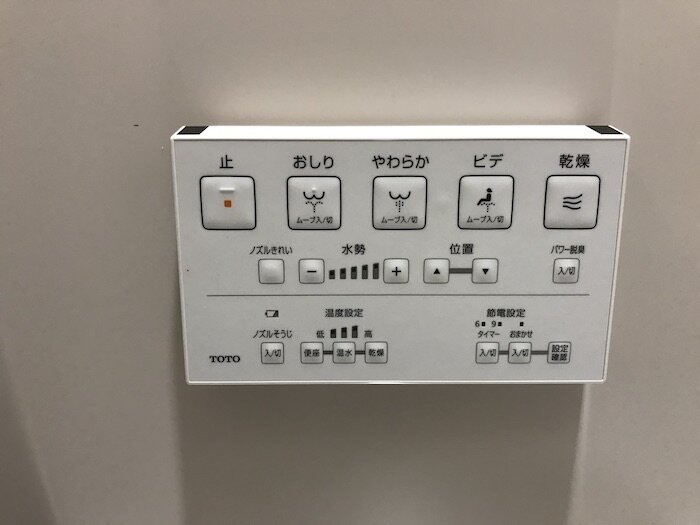 Picture of a different bidet panel (all white) with buttons, icons, and only Japanese writing.