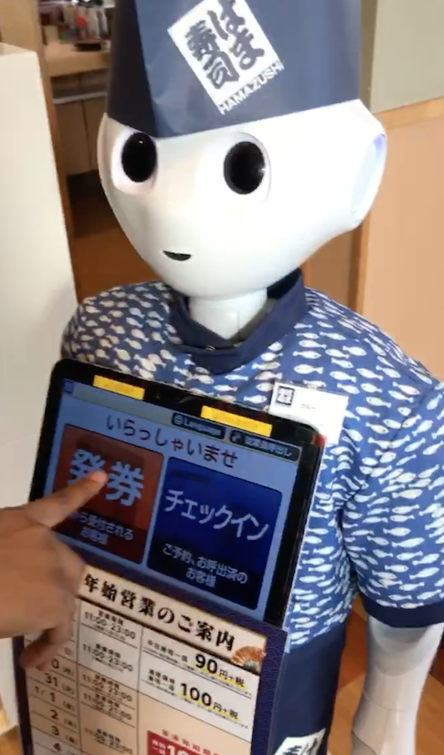 Image of the robot and my brother making selections on the robot’s interface to check us in.
