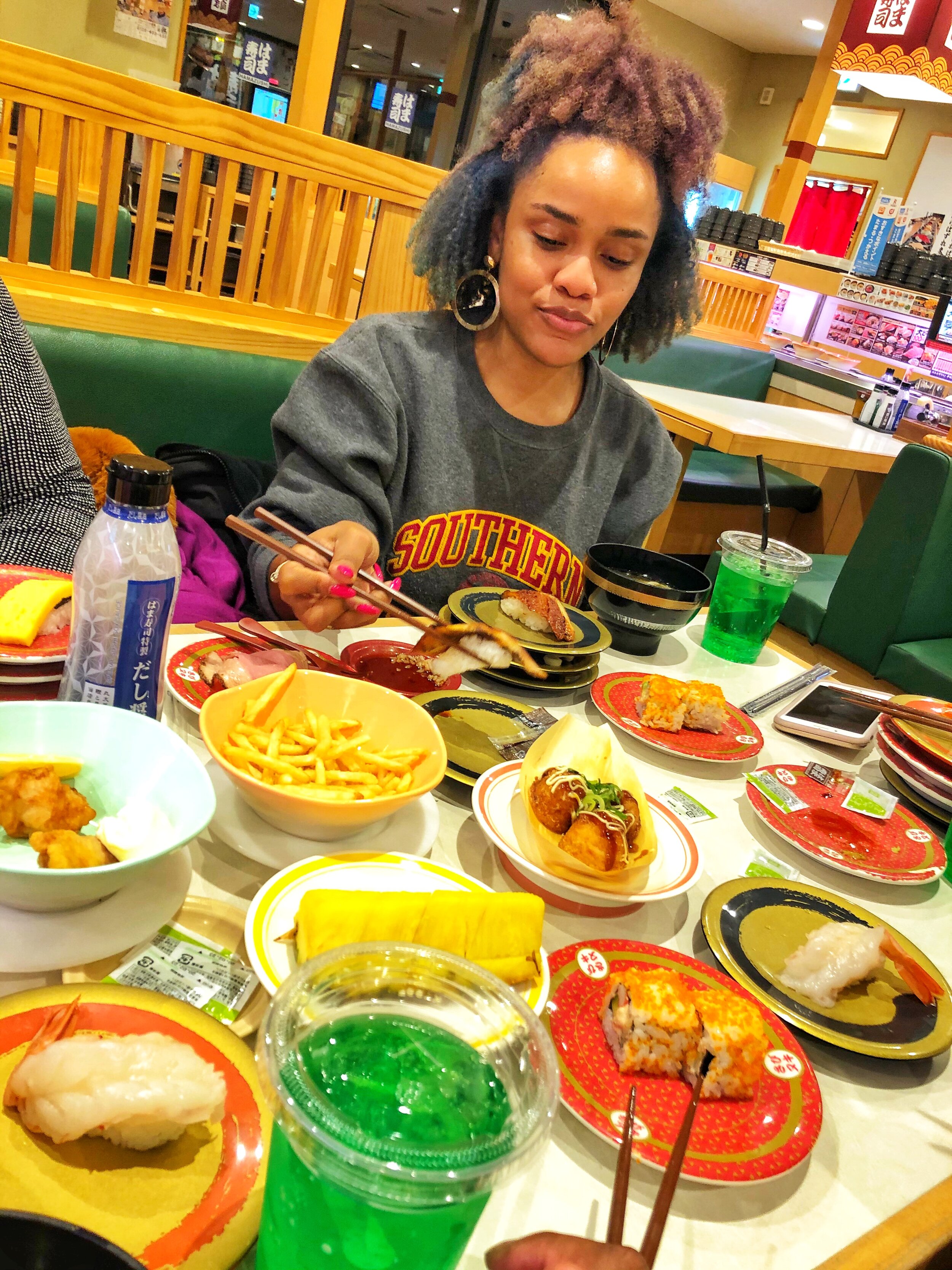 Image of me eating sushi with multiple plates in front of me.