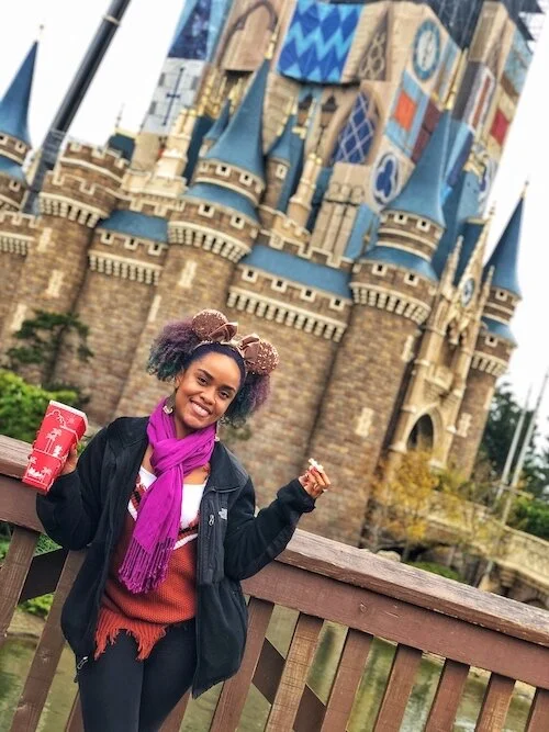 Picture of me standing with popcorn in front of the Tokyo Disneyland castle.