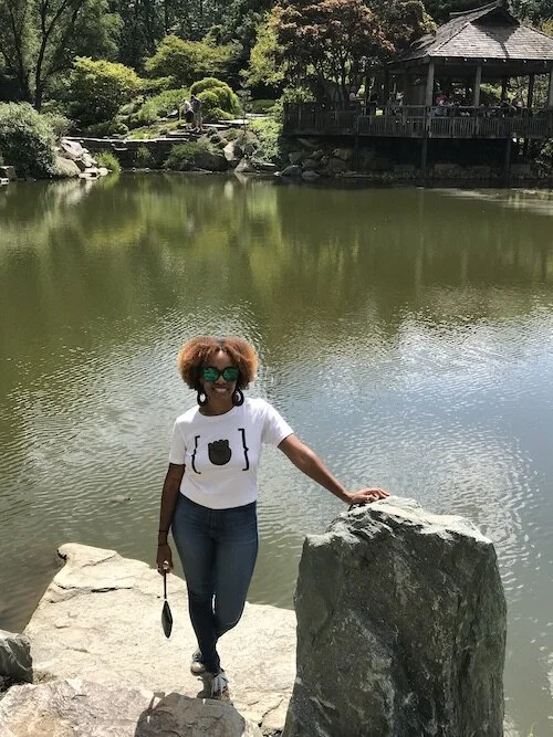 Image of me posing in front of a small lake in the garden.