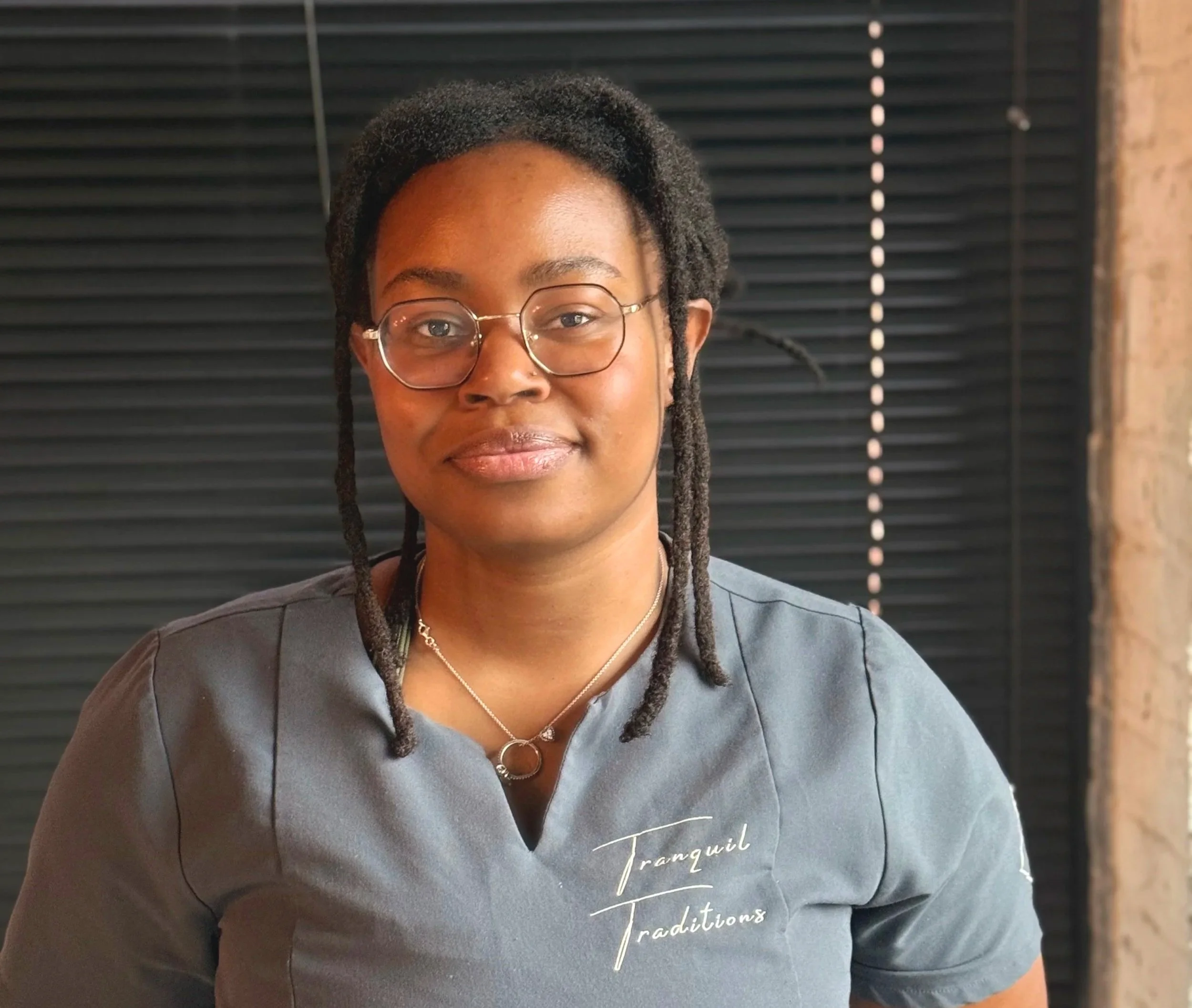 smiling woman with grey grey shirt and black backgound