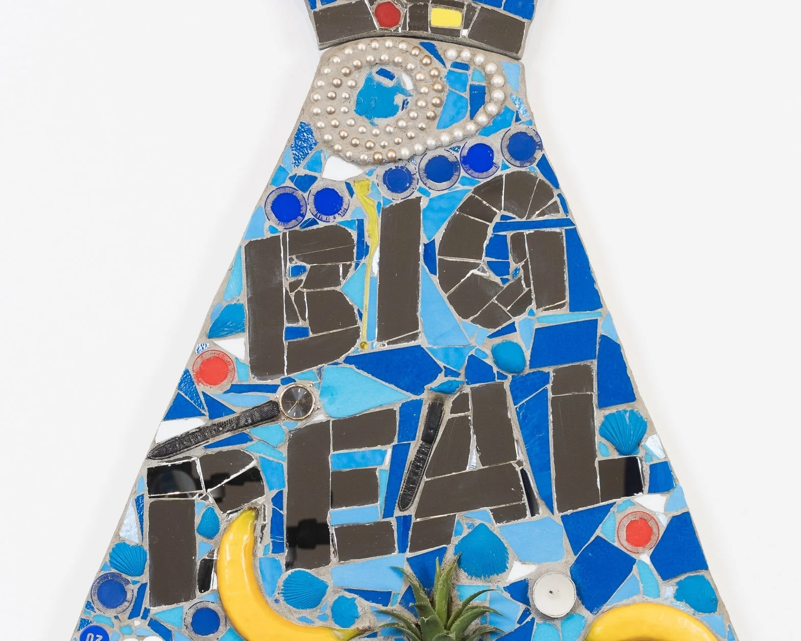 BIG DEAL, 2025 (detail) Foam fruit, plastic pineapple, candles, poker chips, necklaces, watch, bingo chip, plastic flowers, spray-painted plastic cowry shell, plastic fish, shells, house paint, mirror, mortar on compressed foam board, 36” × 55”