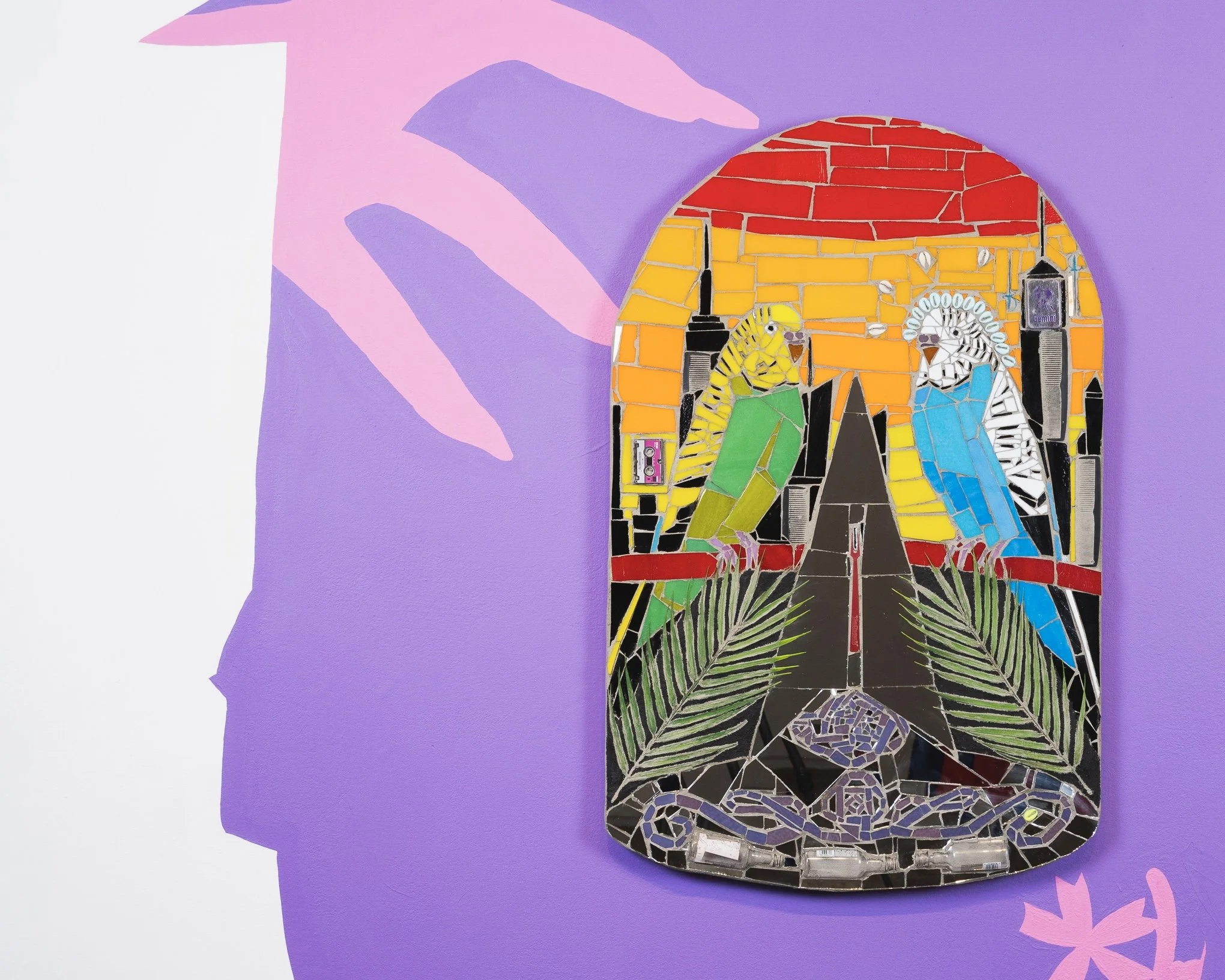 Blue Gemini / Gêmeos Azul, 2025 (detail) Nathan’s French fry fork, plastic palms, miniature liquor bottles, microcassette, combs, cowry shell, plastic cowry shell, mosaic glass, mirror, mortar on compressed foam board; wall painting, 22” × 34.5” (