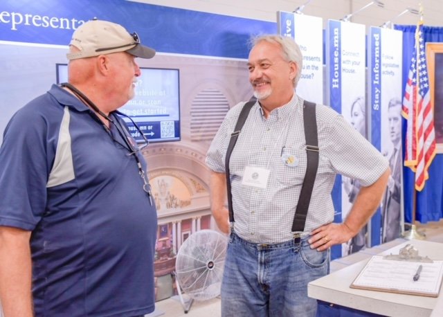 Working at Mn House booth at Mn State Fair. Discussing State Fair poll with Bernie Hesse, retired UFCW