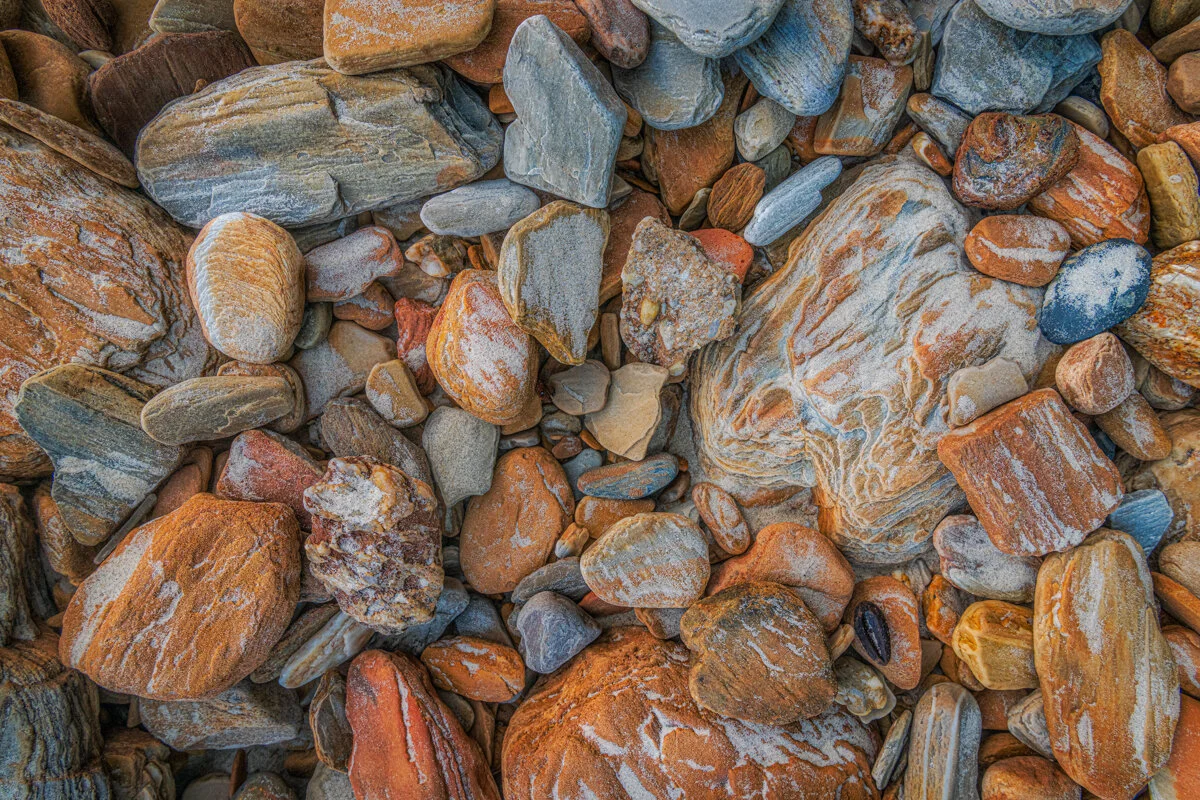"Rocks and Stuff" 2020. Multi colours and tones of rocks in the back beach area of Tyrico beach with thin veneer of sand. 