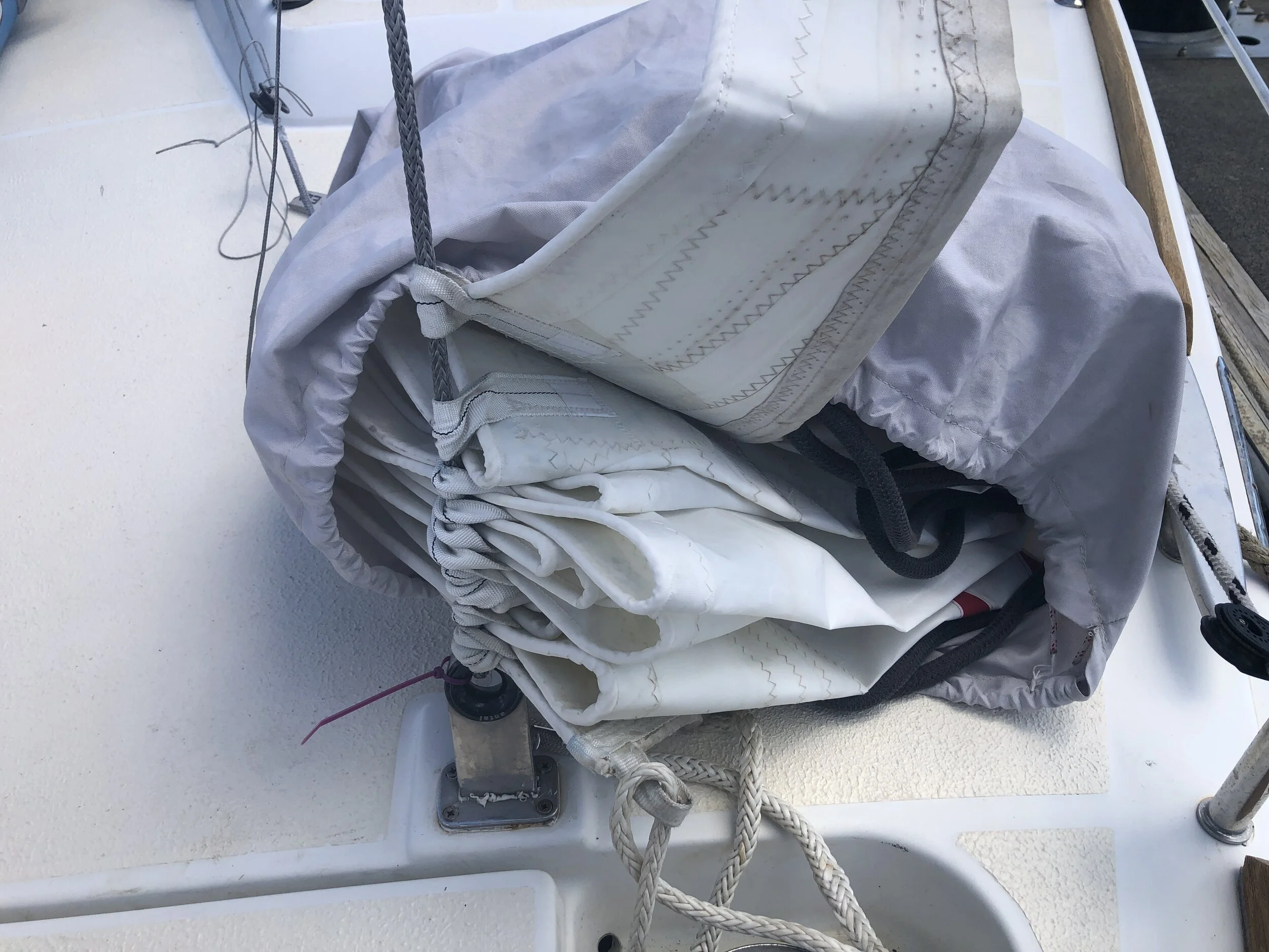 Sail has webbing loops in lieu of metal hanks. The only problem we have is that the sail maker did not make them long enough to slide over a metal shackle which would have been less trouble than the soft one we have to use.