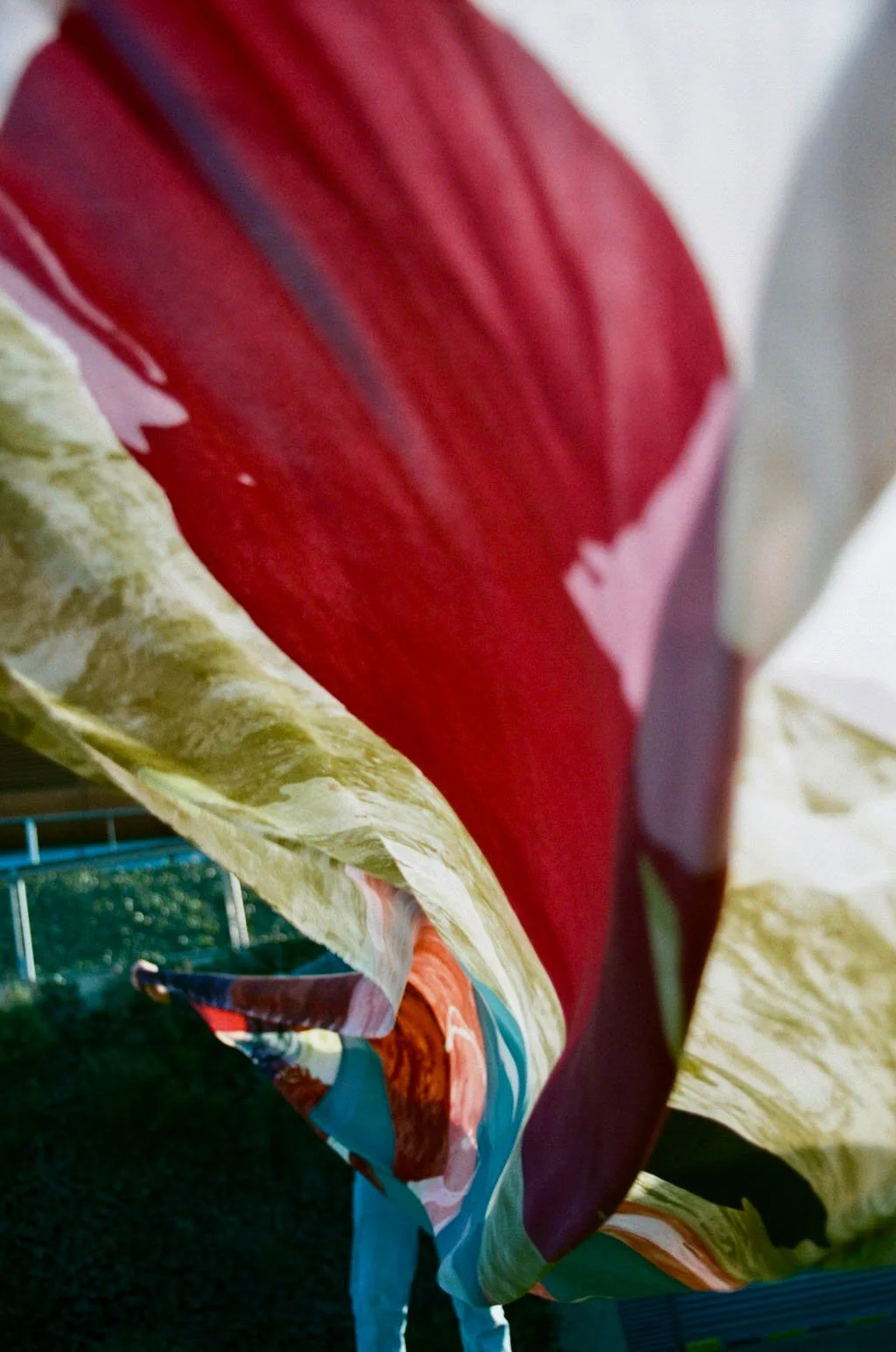 Close-up of a colorful, abstract fabric with red, pink, yellow, and blue sections.