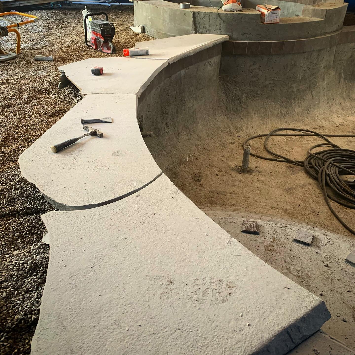 Setting stone coping. Working in a tent that covers the whole pool and spa! #premierpoolandspa #sitevisit #heritagelandscape #landscapearchitecture #hardscape #stones