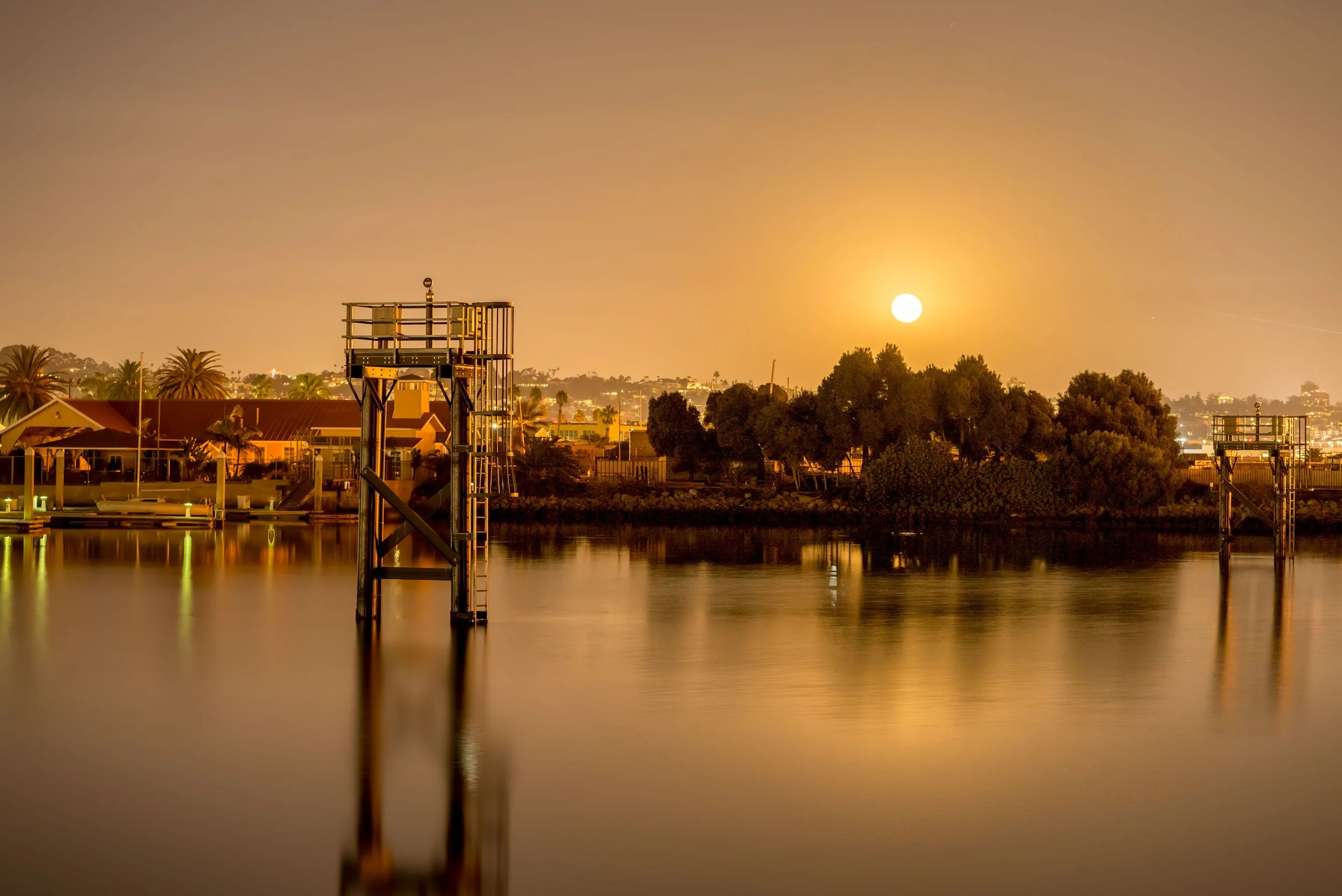Serene night scene of San Diego waterfront with moonlit reflections. San Diego Real Estate. Photo by Jermaine Beckley via Pexels