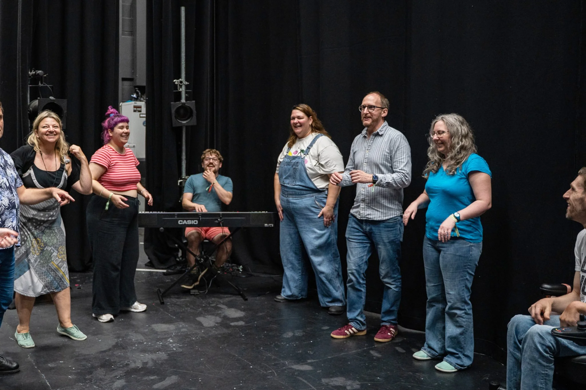 A group of musical improvisers looking out to someone off camera and smiling or laughing