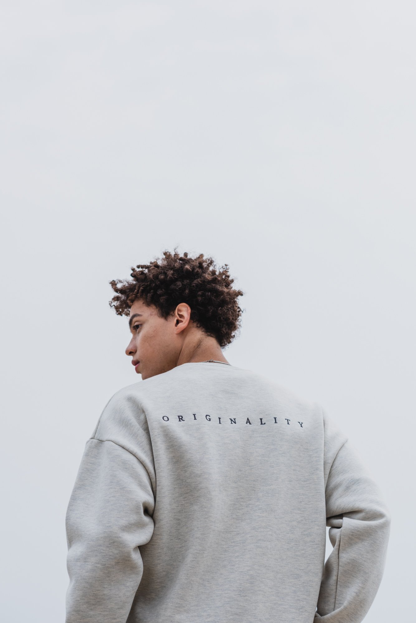 Outdoor fashion photograph of a male model set against the sky