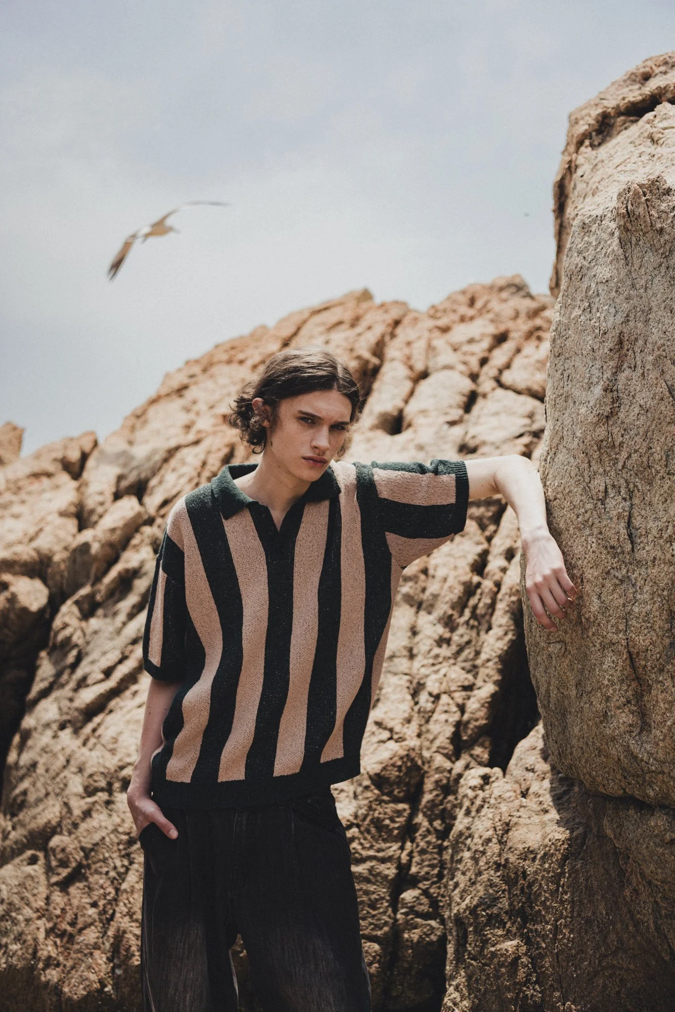Outdoor lookbook photograph of a male model at the beach
