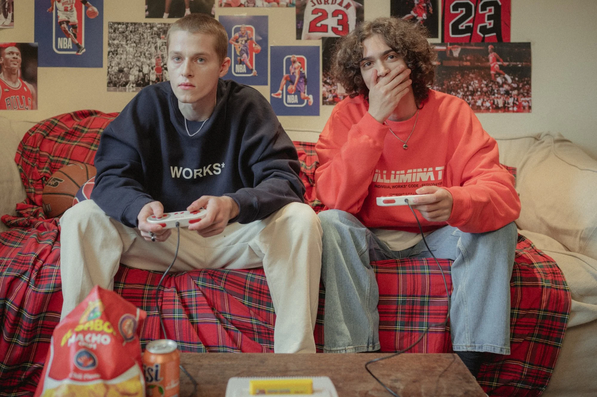 Fashion photograph of two models playing video games on the couch
